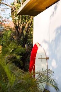 a red and white surfboard sitting next to a building at Nalu Nosara Pool Villa Sol in Playa Guiones