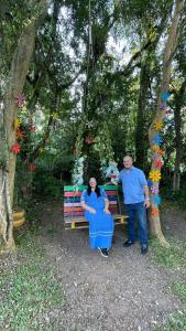 a man and a woman standing in front of a bench at Pousada Recanto Gramado in Gramado