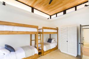 two bunk beds in a room with a loft at Nalu Nosara Pool Villa Jardin in Nosara