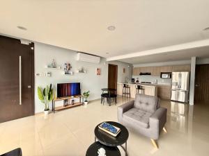 Una sala de estar con una silla y un televisor. en Departamento Boca del Rio Costa de Oro, 
