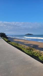 a sidewalk leading to a beach with the ocean at Suíte Toy Story - Pousasa Castelo do Luar in Penha