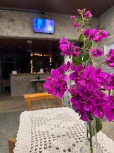 a vase filled with purple flowers sitting on a table at Suíte Toy Story - Pousasa Castelo do Luar in Penha