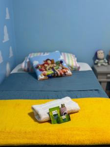 a bed with a towel and a toy on it at Suíte Toy Story - Pousasa Castelo do Luar in Penha +23 photos