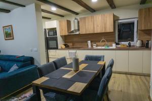 Kuća za odmor Back to Bašić في Mandičevac: مطبخ مع طاولة خشبية وأريكة زرقاء