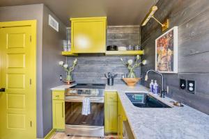 a kitchen with yellow cabinets and a sink at Fayetteville Getaway - Near Campus and Dickson in Fayetteville