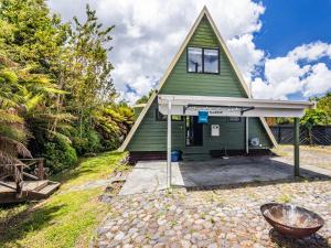 a green house with a gambrel roof at Peaks and Pines Chalet - Ohakune Holiday Home in Ohakune