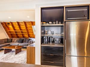 a kitchen and living room with a stainless steel refrigerator at Peaks and Pines Chalet - Ohakune Holiday Home in Ohakune