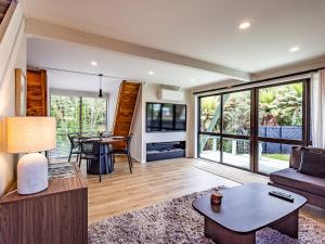 a living room with a couch and a table at Peaks and Pines Chalet - Ohakune Holiday Home in Ohakune