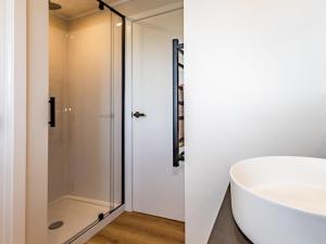 a bathroom with a white tub and a shower at Peaks and Pines Chalet - Ohakune Holiday Home in Ohakune +24 photos