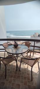 een tafel en stoelen met uitzicht op de oceaan bij Departamento en Playa Pulpos - 2 habitaciones - Piscina compartida in Arica +1 foto