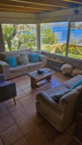 Cabañas Mateo في فيلا بيهوينيا: غرفة معيشة مع كنب وطاولة +7 صور