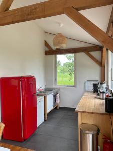 una nevera roja en una cocina con ventana en Milan Farm Chalet cozy, en Milán