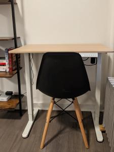 a black chair sitting at a wooden desk at The Bellagio NYC in New York