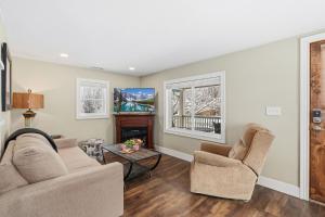a living room with two chairs and a fireplace at Kanons Kottage Downtown Retreat Near RMNP in Loveland