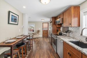 a kitchen with wooden cabinets and a counter top at Kanons Kottage Downtown Retreat Near RMNP in Loveland
