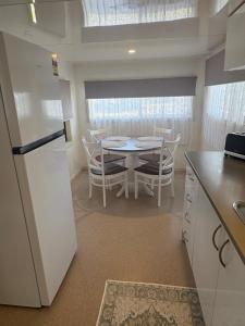a kitchen with a white refrigerator and a table with chairs at Turners Beach Holiday Cabin in Turners Beach