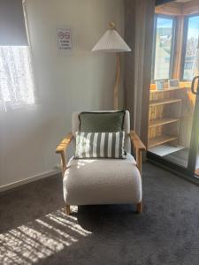 a chair with a pillow sitting in a room at Turners Beach Holiday Cabin in Turners Beach