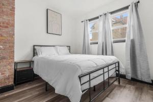 a bed in a room with a large window at Charming 4BR Niagara Apartment Great Location in Niagara Falls