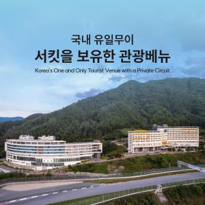 a sign for a hotel with two buildings and a highway at Take Hotel & Resort Inje Speedium in Inje