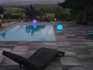 a swimming pool with blue and purple spheres next to a chair at Charmant logement in Lamentin