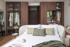 a bedroom with a white bed with pillows at Luxury villa Zara, first row to the sea! in Kali +34 photos