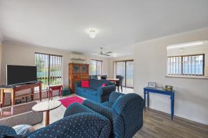 a living room with blue couches and a flat screen tv at Pet Friendly in Port Elliot in Port Elliot