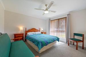 a bedroom with a bed and a couch and a window at Pet Friendly in Port Elliot in Port Elliot