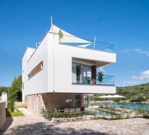 a white house with a swimming pool at Luxury villa Zara, first row to the sea! in Kali