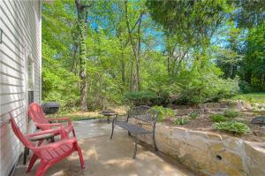 two red chairs and a table on a patio at The American Carriage House in Liberty