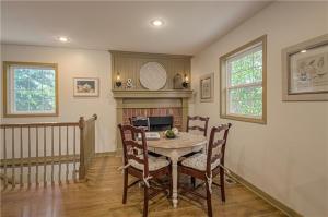 a dining room with a table and chairs and a fireplace at The American Carriage House in Liberty