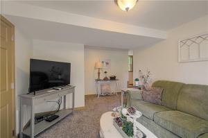a living room with a couch and a tv at The American Carriage House in Liberty