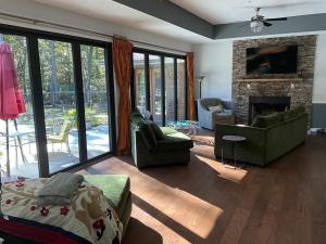 a living room with a couch and a fireplace at Quiet Forest Vacation home on a Private Road with Spacious Patios, Fire pit, Pet friendly and a Private pool in Tullahoma
