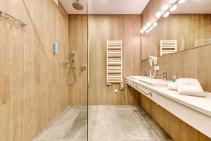 uma casa de banho com um chuveiro, um lavatório e um espelho. em Baltic Sands em Hel