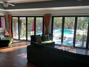 a living room with a couch and a view of a pool at Quiet Forest Vacation home on a Private Road with Spacious Patios, Fire pit, Pet friendly and a Private pool in Tullahoma