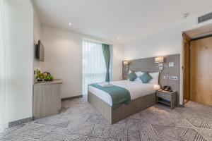 um quarto de hotel com uma cama grande e uma janela em The Lion & Key Hotel em Londres