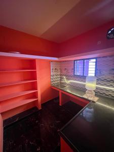 a room with red walls and a desk with a window at Love Home stay in Dharmpura