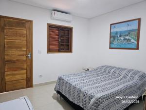 a white bedroom with a bed and a window at Flor de Jagube Guest House in Ubatuba +87 photos