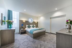 um quarto de hotel com uma cama, uma secretária e uma janela em The Lion & Key Hotel em Londres