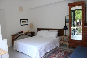 um quarto com uma grande cama branca e uma janela em Nel Giardino degli Agrumi em Palermo