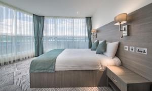 a bedroom with a large bed and a large window at The Lion & Key Hotel in London