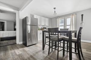a kitchen with a table and chairs and a refrigerator at 4BR Niagara Falls Home Free Parking WiFi in Niagara Falls