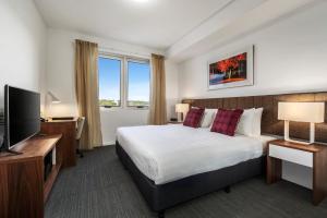 a hotel room with a bed and a flat screen tv at Quest Toowoomba in Toowoomba