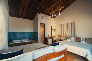 een slaapkamer met twee bedden en een bad bij Hotel Via Do Sol Eco Chalés in Trairi