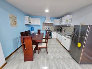 a kitchen with a wooden table and a refrigerator at Hospedaje Familiar Ecuador in Cuenca +17 photos