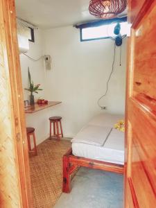 a small room with a bed and a window at The Village Eco-Bungalows in Salvacion, Busuanga in Busuanga