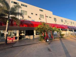 Hotel Via Montes في مونتيس كلاروس: دراجة نارية متوقفة أمام مبنى به أشجار النخيل