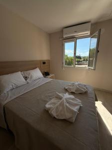 a bedroom with a large bed with two towels on it at Hotel Playas De Oro in Villa Carlos Paz +6 photos
