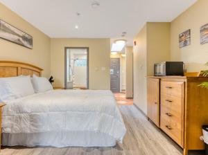 a bedroom with a white bed and a microwave at Oceanside Getaway in Nanoose Bay +28 photos