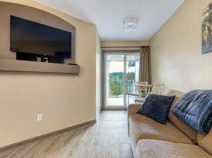 a living room with a couch and a flat screen tv at Oceanside Getaway in Nanoose Bay
