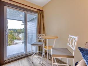 a room with a table and chairs and a window at Oceanside Getaway in Nanoose Bay